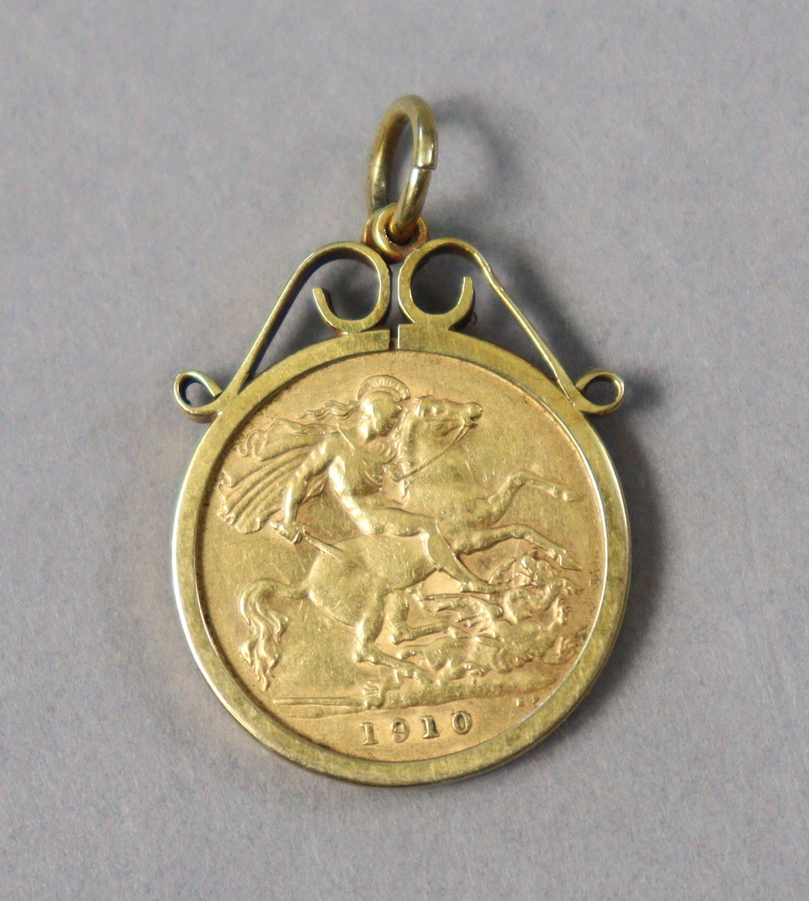 An Edwardian gold half-sovereign, 1910, loose-set in 9ct gold pendant mount.