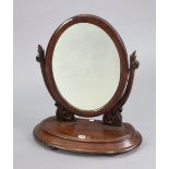 A 19th century mahogany oval swing toilet glass with carved scroll supports, & with a hinged