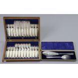 A pair of silver plated fish servers; & a similar set of twelve pairs of fish eaters, both cased.