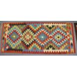 A Chobi kilim small runner with multicoloured lozenge design in ochre borders, 146cm x 62cm.