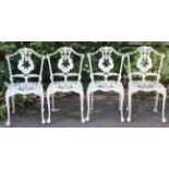 A set of four Victorian-style white painted aluminium garden chairs each with a pierced back & seat,