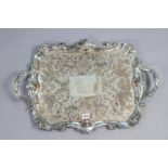 An early 20th century engraved silver-plated two-handled rectangular tea tray with a raised scroll