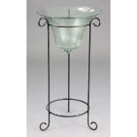 A glass bell-shaped jardiniere on a wrought-iron stand, 17” diameter x 32½” high.