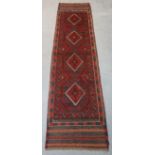 A Meshwani runner of madder & deep blue ground with repeating lozenge motif, 232cm x 57cm.