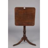 A 19th century oak tripod table having rounded corners to the rectangular tilt-top, & on a vase-