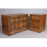 An Ercol oak dwarf cabinet enclosed by a hinged lift-lid & a pair of panel doors, 38½” wide x 27¾” h