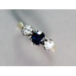 An 18ct. gold ring set round-cut sapphire between two diamonds; size: O; 3.1 gm.