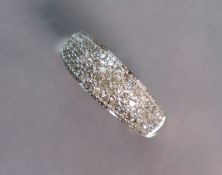 A 9ct. gold ring pavé-set with numerous small diamonds; size: P/Q; 3.3 gm.