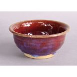 DAVID FRY (b. 1948). A flambé glazed stoneware bowl with flared rim & on short foot, 15cm diam. x