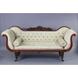 A Victorian three-seater sofa with scroll ends & carved backrest, on carved tapering legs with brass