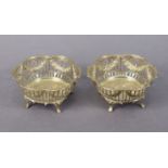 A pair of Edwardian silver lobed circular sweetmeat dishes with flower swags to the pierced sides,