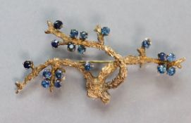 A 14K yellow brooch naturalistically modelled as tree branches set eighteen small sapphire; 6.4 cm