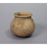 A southeast Asian earthenware small pot of globular form with incised decoration & floral rim,