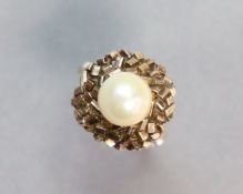 A yellow metal ring set cultured pearl within a “brick” border; size: L; 4.3 gm.