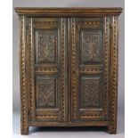A late 17th/early 18th century oak cupboard enclosed pair of carved panel doors with inlaid