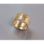 A broad 9ct. gold band with herringbone pattern; size: P/Q; 7.2 gm.