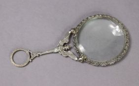 A continental silver magnifying glass with decorative border, & winged cariatide forming the handle,