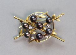 A yellow 14K open-work brooch designed as crossed bamboo canes centred by a hoop, set seven cultured