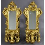 A pair of reproduction girandoles, each with narrow rectangular bevelled plate in gilt rococo