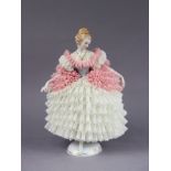 A Sitzendorf porcelain figure of a female dancer in white & pink dress, on gilt decorated circular