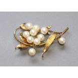 A 14K foliate brooch set ten cultured pearls, 4.8 cm long. (6.4 gm).