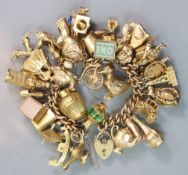 A 9ct. gold curb-link bracelet with padlock clasp, & thirty four various pendant charms, all with