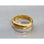 A 22ct. gold wedding band; size: M; 7.3 gm.