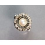 A white metal ring set cultured pearl with an open border of small diamonds; size: P; 5.5. gm.