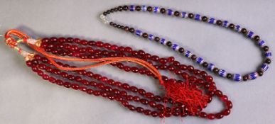 A necklace of antique six-layer overlaid glass beads with contemporary garnet spacers; & a multi-str