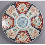 A 19th century Japanese Imari porcelain charger, decorated with alternating panels of auspicious