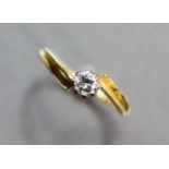 A yellow metal cross-over ring set single diamonds; size: P; 2 gm.