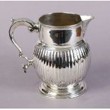 A silver jug with plain cylindrical neck, fluted ovoid body, scroll handle, & on moulded circular