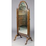 An early 20th century Queen Anne-style walnut-veneered cheval mirror, the cushion-moulded frame