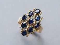 A 14K yellow abstract design ring set nine oval-cut sapphires; size: Q; 4.4 gm.