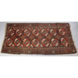 An antique Caucasian rug of multicoloured geometric design with two rows of seven octagonal panels