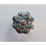 A 14K yellow ring set seventeen small sapphires in tiered concentric rows; size: Q; 4.4. gm.