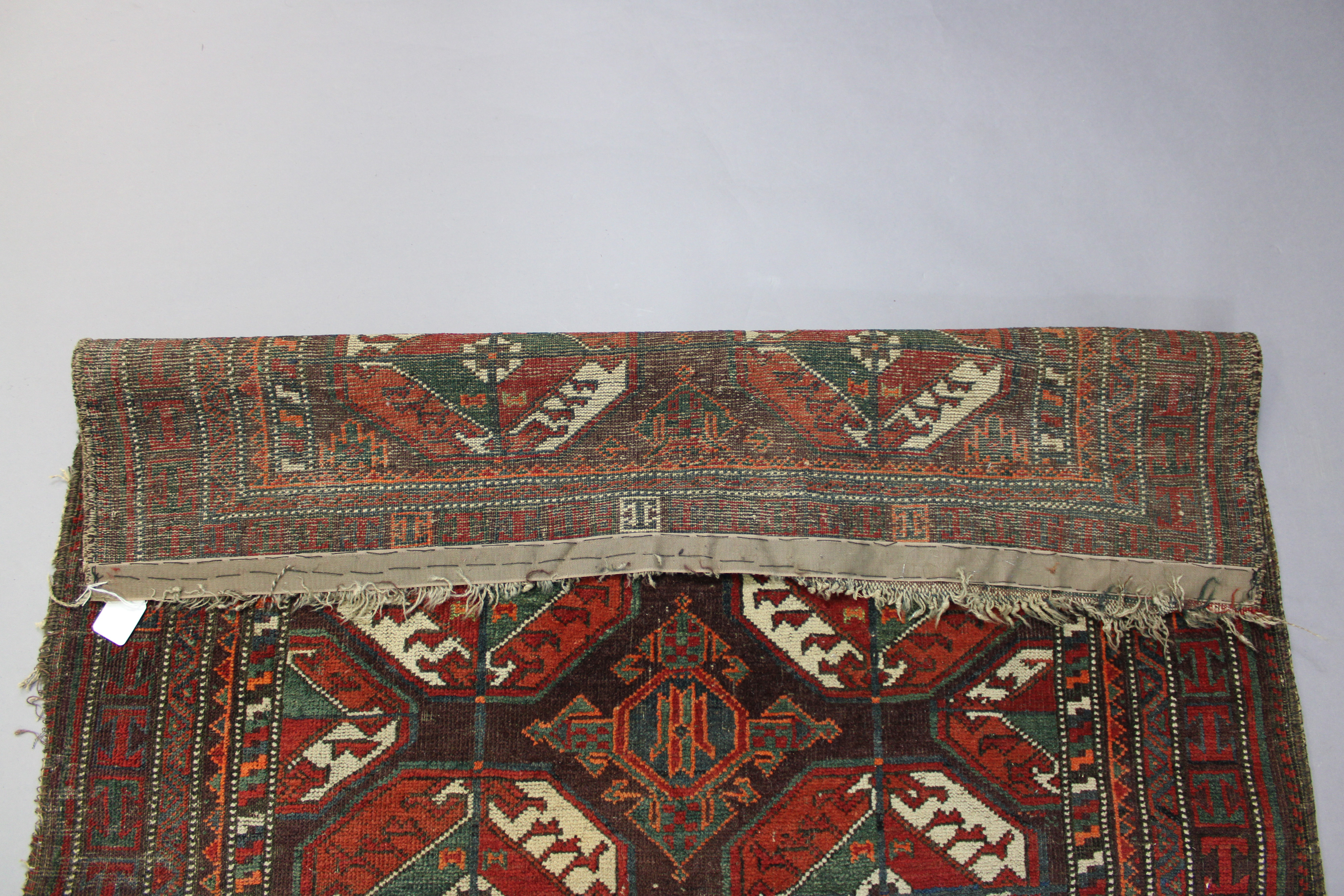 An antique Caucasian rug of multicoloured geometric design with two rows of seven octagonal panels - Image 3 of 3