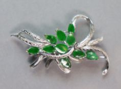 A 14K white leaf-spray brooch set ten green jade leaves; 5.3 cm long. (6.3 gm).