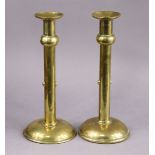 A pair of Arts & Crafts brass candlesticks on plain columns & domed circular bases, 25cm high.