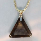 A triangular-cut smokey quartz pendant set in yellow 14K mount with pierced scroll sides, on