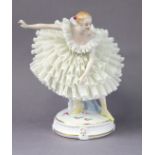 A Sitzendorf porcelain figure of a ballerina on gilt decorated circular base with scattered flowers,