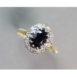 An 18ct. gold ring set oval-cut sapphire within a border of small diamonds; size: R; 3.7 gm.