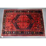 A north west Persian Zanjan rug of madder ground with a central lozenge surrounded by flower-heads &