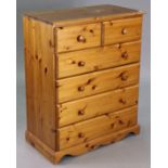 A pine small chest fitted two short & four long drawers with turned knob handles, & on a shaped