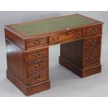 A reproduction mahogany pedestal desk inset gilt-tooled green leather, fitted three frieze