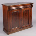 A Victorian mahogany dwarf cabinet having a centre shelf enclosed by a pair of panel doors, & on a