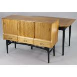 A 1960’s teak draw-leaf dining table the black-finish base on four square tapered legs, 29½” x