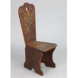 An early 20th century Arts & Crafts carved oak spinning stool, signed & dated “D.J.M. 1902” to the