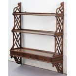 A set of 19th century-style mahogany three-tier wall shelves fitted three small drawers to the lower