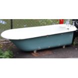 A vintage white enamelled bathtub fitted with a pair of chrome-plated taps, 72” long.